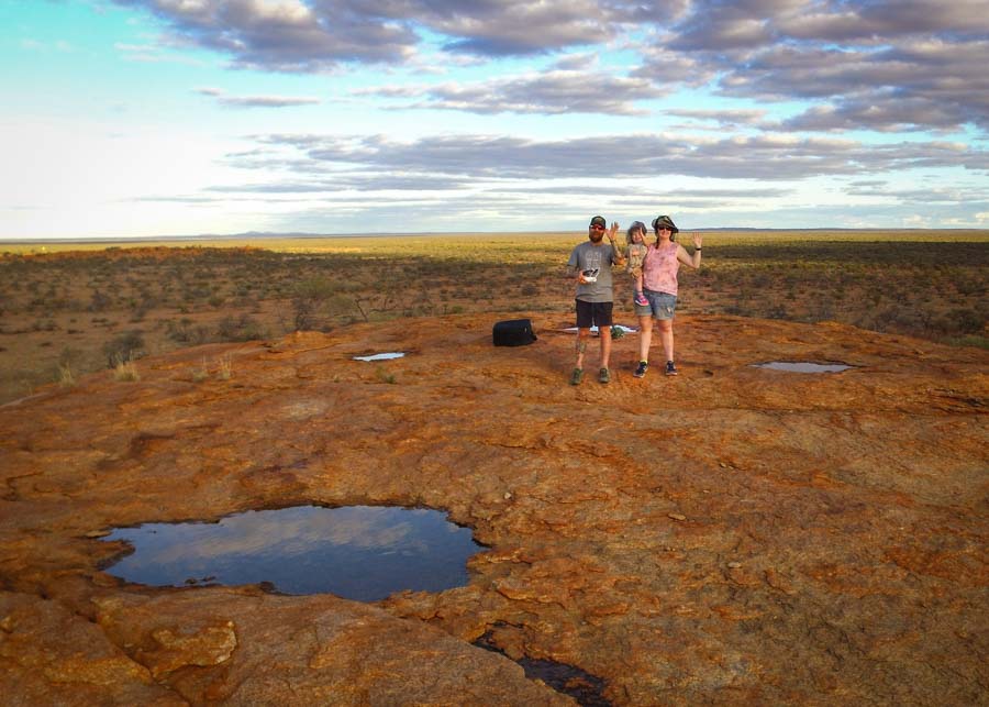 Suzy, Jed and Maddie standing on a large granite boulder high above the surrounding landscape